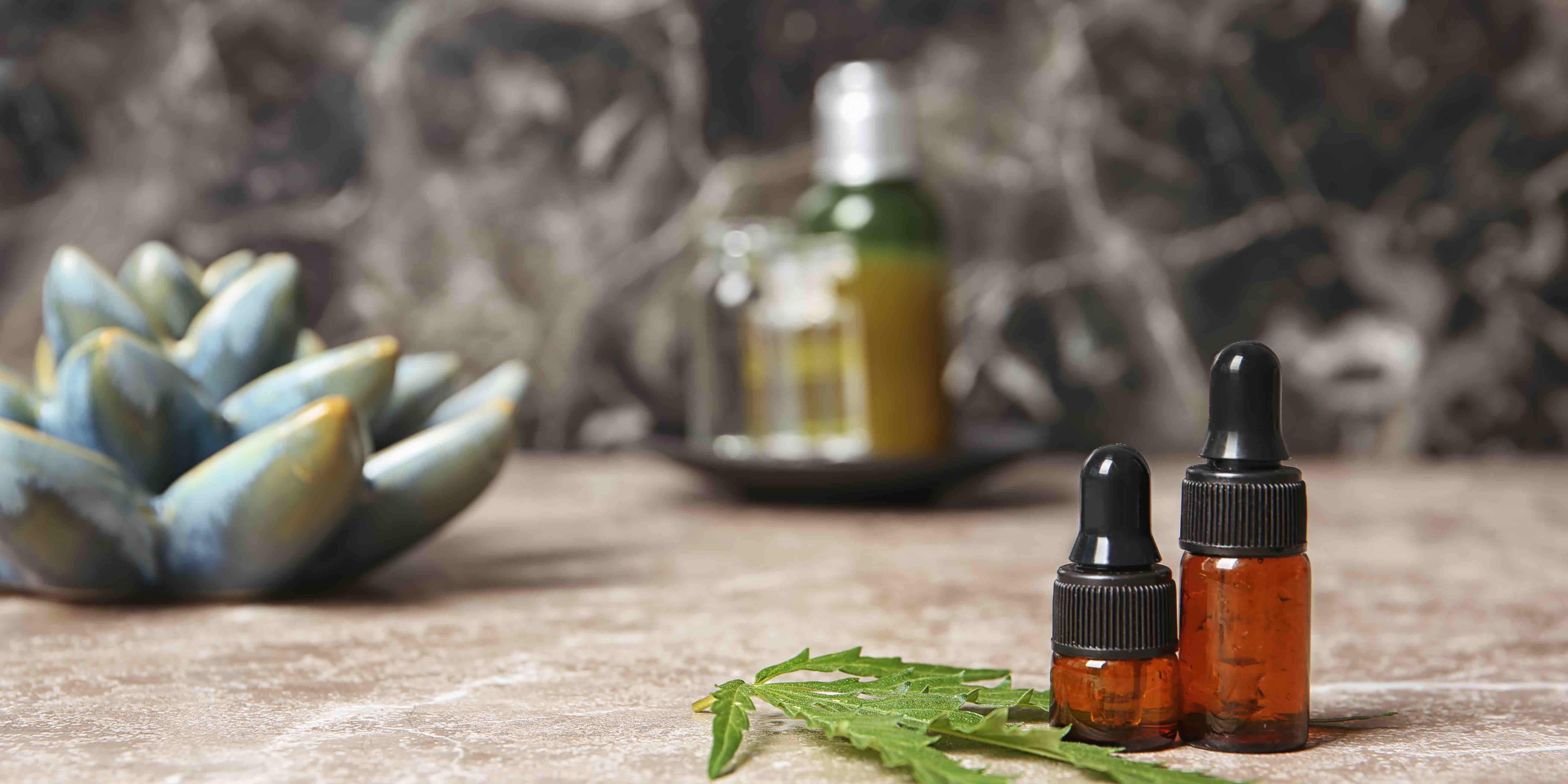 Composition with hemp lotion on grey table. Space for text